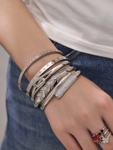 Close-up of stacked silver bracelets featuring star motifs and sparkling cubic zirconia