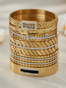 Detail of gold stacked bracelets with geometric patterns, zircons and marble inlay