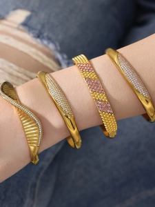 Close-up of a stacked 18k gold plated stainless steel bracelet set with zircon inlays