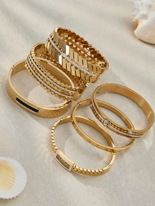 Set of 6 gold plated geometric bangles with zircon and textures on a beach setting