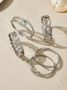 Detailansicht von vier polierten silbernen Armbändern mit Zirkonia und Blattmustern