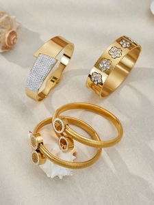 Dettaglio di un set di bracciali in acciaio placcato oro 18k con zirconi e albero della vita