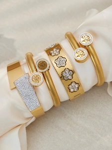 Dettaglio del set di cinque bracciali dorati con zirconi e motivo albero della vita