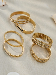 Close-up of gold stainless steel bangle set with zircon and honeycomb patterns