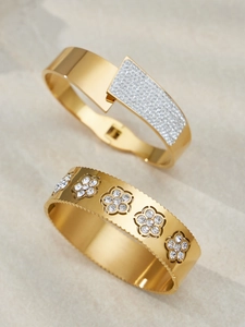 Dettaglio di bracciali placcati oro 18k con zirconi e motivi floreali e geometrici
