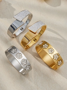 Dettaglio di bracciali in acciaio inossidabile placcato oro 18k con fiori di zircone e motivi