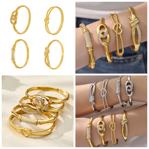 Dettaglio di quattro bracciali a strati in oro e argento con accenti in zirconi