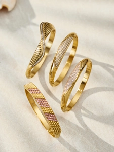 Detailed view of four 18k gold plated stainless steel bangles with zircon inlay on stone
