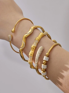 Close-up of five 18k gold plated stainless steel bracelets with sparkling cubic zirconia