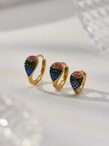 Détail macro de boucles d'oreilles goutte en or 18k avec zircons dégradés rose vert bleu