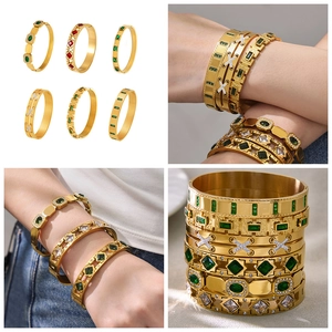 Detail of vintage gold-plated stainless steel bangles with emerald and ruby accents