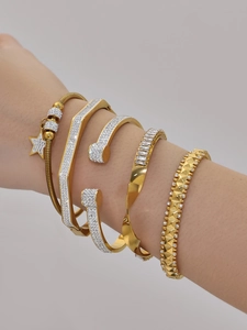 Gros plan de bracelets joncs plaqués or 18 carats avec zircon 5A sur le poignet d'un modèle