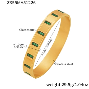 Detail of 18k gold plated stainless steel bangle featuring emerald green glass stones