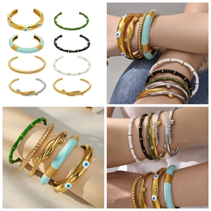 Dettaglio di bracciali rigidi in acciaio inossidabile smaltato con finitura oro e argento