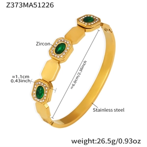 Detailed close-up of 18k gold plated stainless steel bangle with green emerald zircons