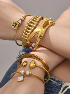 Bracciali dorati sovrapposti con ciondolo Albero della Vita e stili geometrici