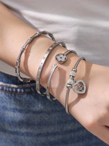 Dettaglio di bracciali in acciaio inossidabile placcato oro 18k con zircone e cuore