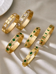 Detailed view of 18k gold plated bracelets set with emerald and clear zircon gems