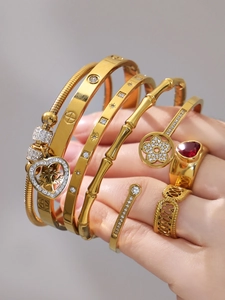 Dettaglio del set di bracciali in acciaio dorato con zirconi indossato dal modello
