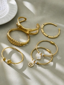 Dettaglio set di bracciali in acciaio dorato con ciondolo Albero della Vita e cristalli