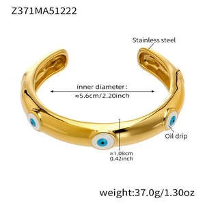 Dettaglio del bracciale a polsino in acciaio dorato con occhio smaltato blu e dimensioni