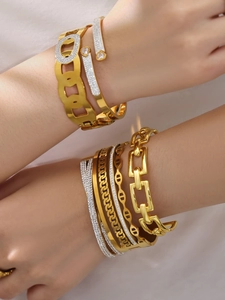 Detalle macro de pulseras en capas chapadas en oro de 18k con circonitas y eslabones