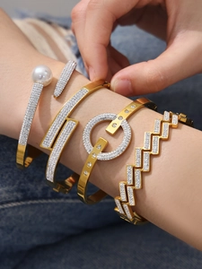 Détail de bracelets dorés géométriques avec zircons 5A et perles sur denim