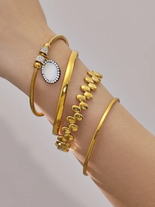 Detailaufnahme von vierteiligem goldfarbenem Armband-Set mit Schlangenkette und Anhänger