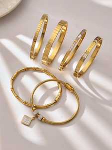 Detalle del conjunto de pulseras de acero bañado en oro 18k con circón y números romanos