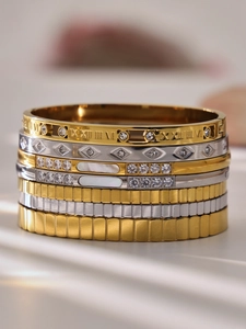 Vista macro de pulseras apiladas con números romanos e incrustaciones de nácar fino