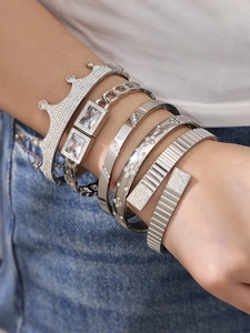 Detail von silbernem 5-teiligem Armreif-Set mit Kronenmotiv und Zirkonia am Handgelenk