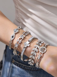 Detailansicht der silbernen Bettelarmbänder mit Teufelsauge, Stern und Blumen aus Zirkon