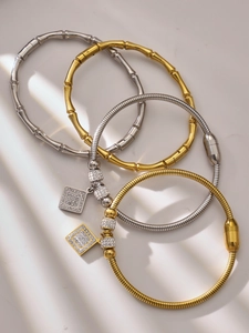 Detalle de pulseras bañadas en oro 18k con circonitas y texturas geométricas elegantes