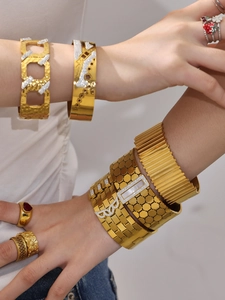 Detailed view of layered 18k gold plated honeycomb bangles and zircon rings on model