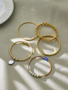 Detaillierte Makroansicht eines fünfteiligen vergoldeten Armband-Sets mit Kristallen und Kette