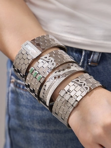 Macro shot of silver honeycomb textured bracelets with zircon stones on a model
