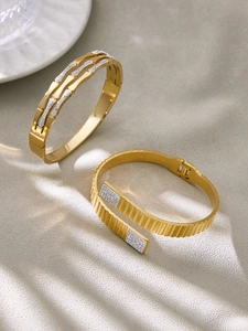 Detailansicht der 18k vergoldeten Kronenarmreifen mit Zirkonia und plissierter Textur