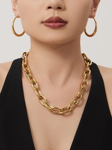 Detailansicht der 18k vergoldeten Gliederkette und Creolen an einem Model