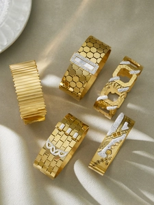 Detailed close-up of 18k gold-plated honeycomb and geometric zircon bangles set