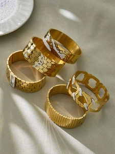 Flat lay of five gold-plated bangle set with honeycomb texture and butterfly zircon detail