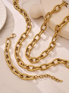 Detail einer 18k vergoldeten Gliederkette mit Karabinerverschluss auf Marmorboden