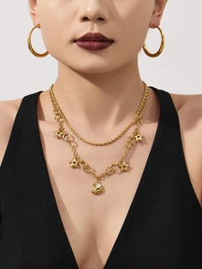 Détail du collier doré multi-rangs à pendentifs étoile et lune avec de grandes créoles