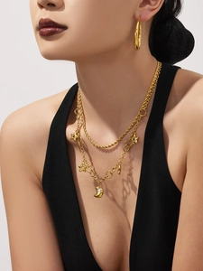 Détail d'un collier doré à deux rangs avec pendentifs étoile et lune sur un mannequin