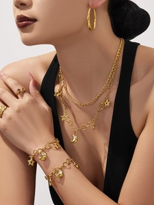 Gros plan d'un ensemble de bijoux dorés avec pendentifs étoile et lune sur un mannequin
