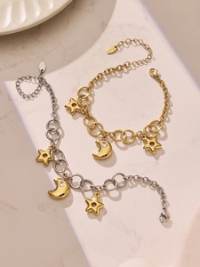 Détail de pendentifs étoile et lune sur des bracelets à maillons en acier inoxydable doré