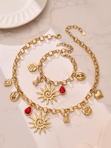 Detail view of chunky gold chain necklace and bracelet set with sun and bear pendants