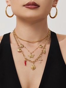 Detail of layered gold necklace featuring multi-element charms and heart pendants