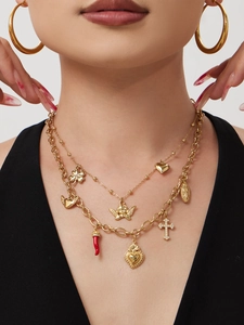Detailed view of 18k gold-plated layered necklace with diverse mixed symbolic charms on model