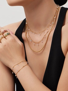 Detailansicht der 18k vergoldeten Halskette mit Quasten und Zirkonia-Armband am Modell