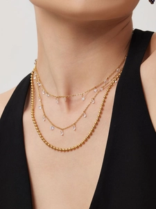 Detail einer dreilagigen goldenen Quastenkette mit funkelnden 5A-Zirkonia-Anhängern am Modell